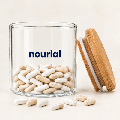 Nourial glass jar open, partly filled with powder capsules