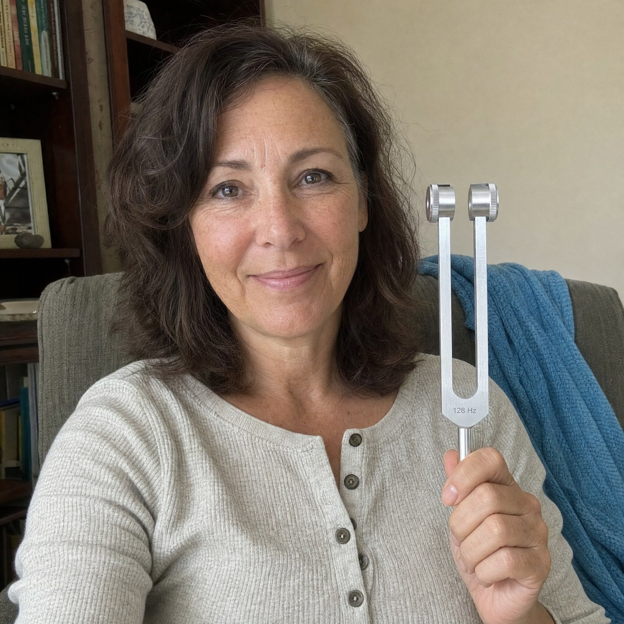 Woman holding a Nourial healing instrument at home