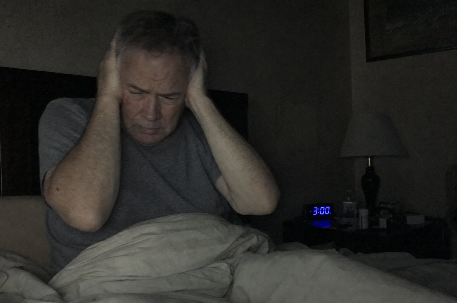 Awake at 3 AM, hands over both ears